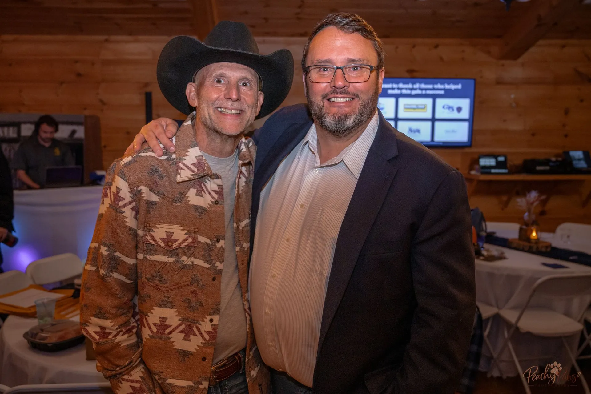 Two guests sharing a warm moment of camaraderie at the gala
